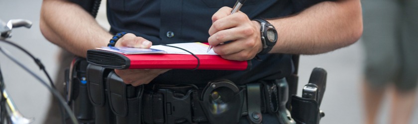 Photo of a police officer writing a cite and release ticket